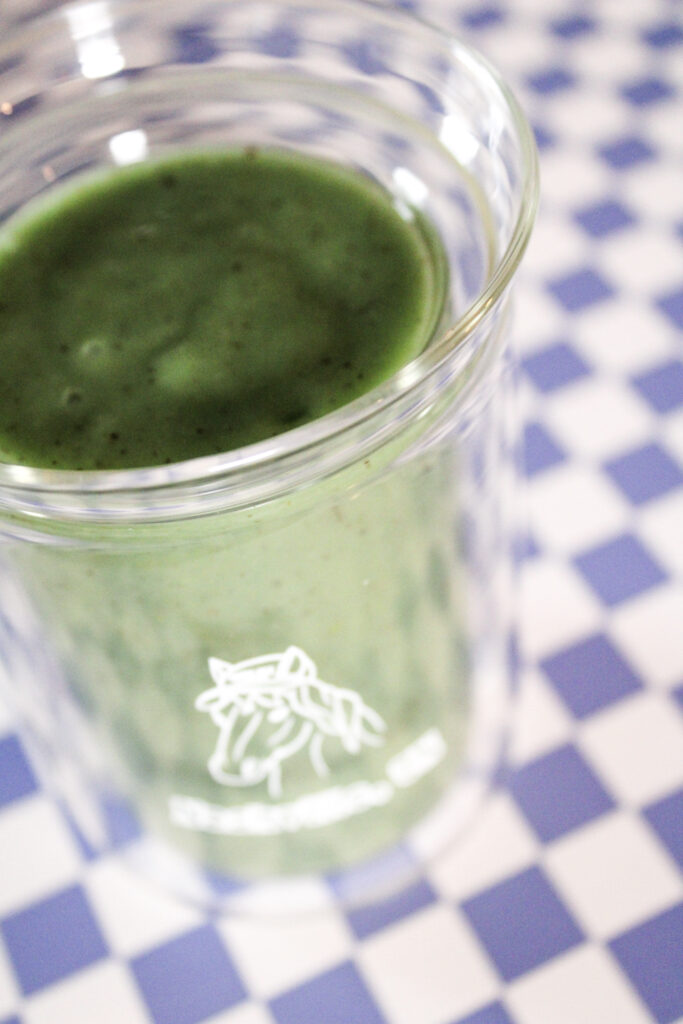 A green smoothie on a purple checkered background.