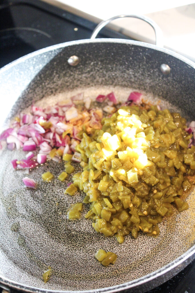 Green chiles and onions in a pan.