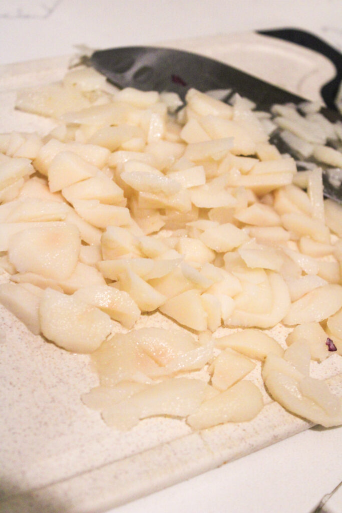 Chopped water chesnuts on a cutting board.
