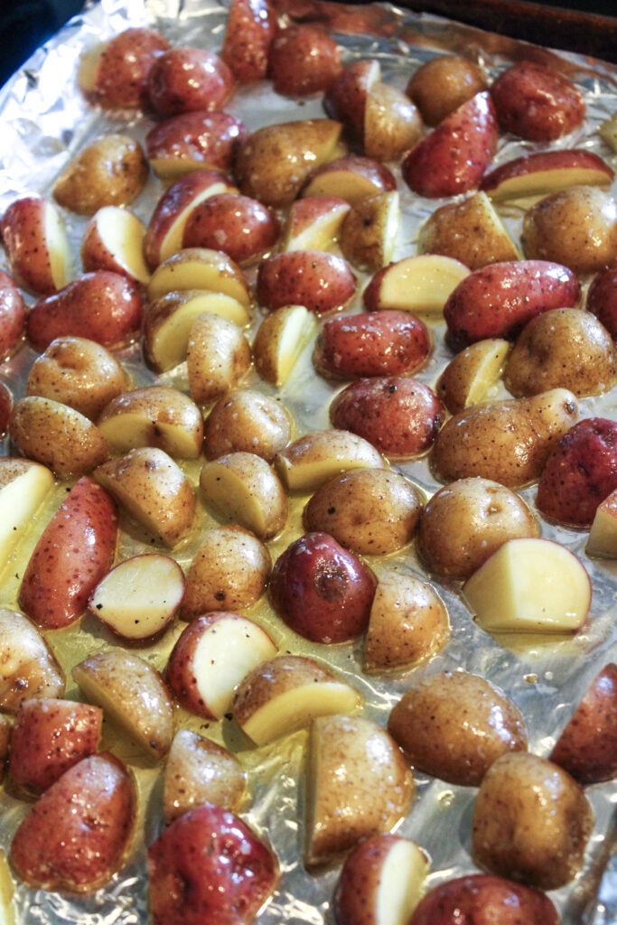 Sliced fingerling potatoes on a sheet pan.