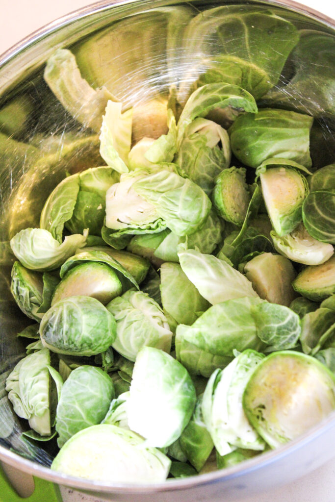 Sliced brussel sprouts in a metal bowl.