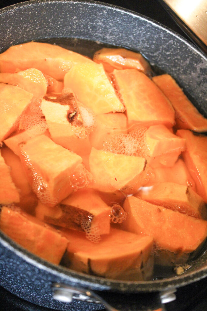 Sweet potato pieces boiling in a pot.