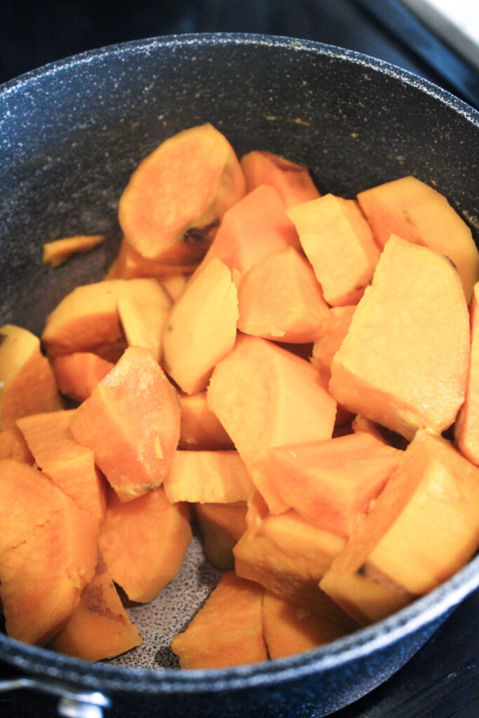 Sweet potato pieces that have been drained and placed back into the pot.
